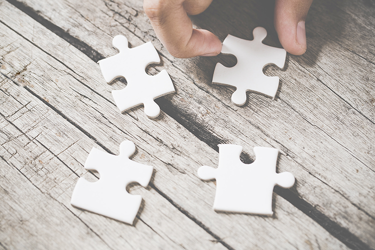 4 Puzzleteile auf einem Tisch, die noch nicht zusammengefügt wurden.